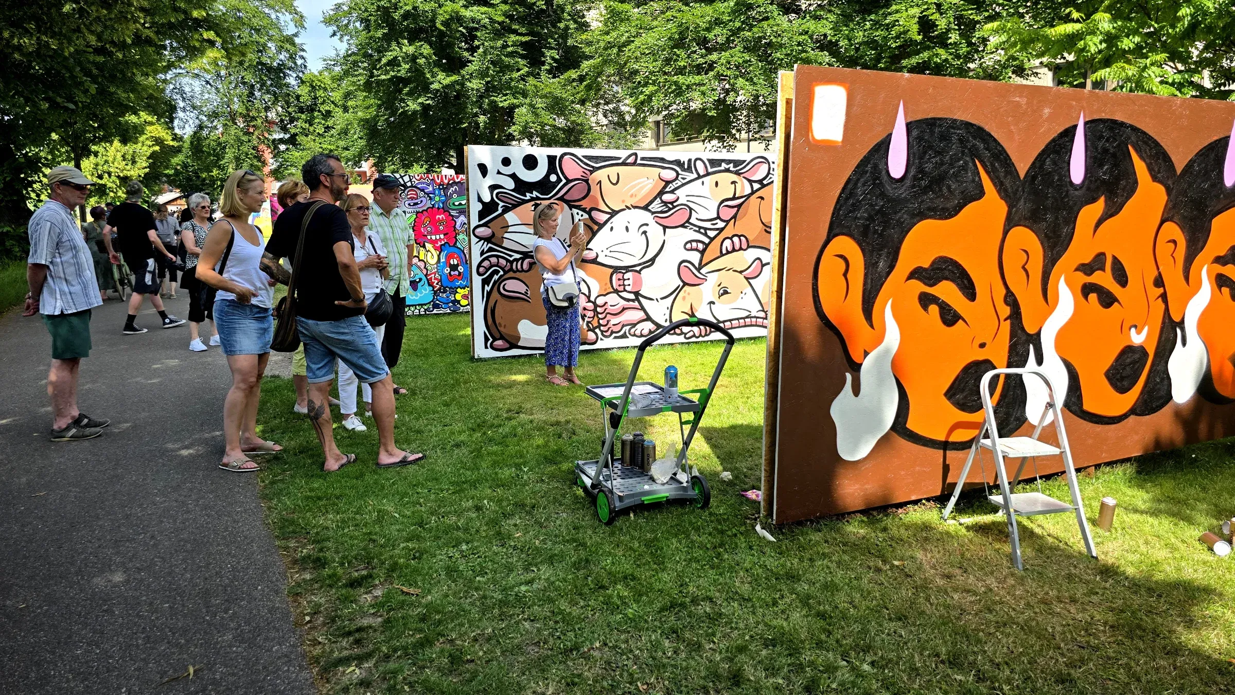 Besucherinnen und Besucher vor den bemalten Panels des International Jam im Lindenpark